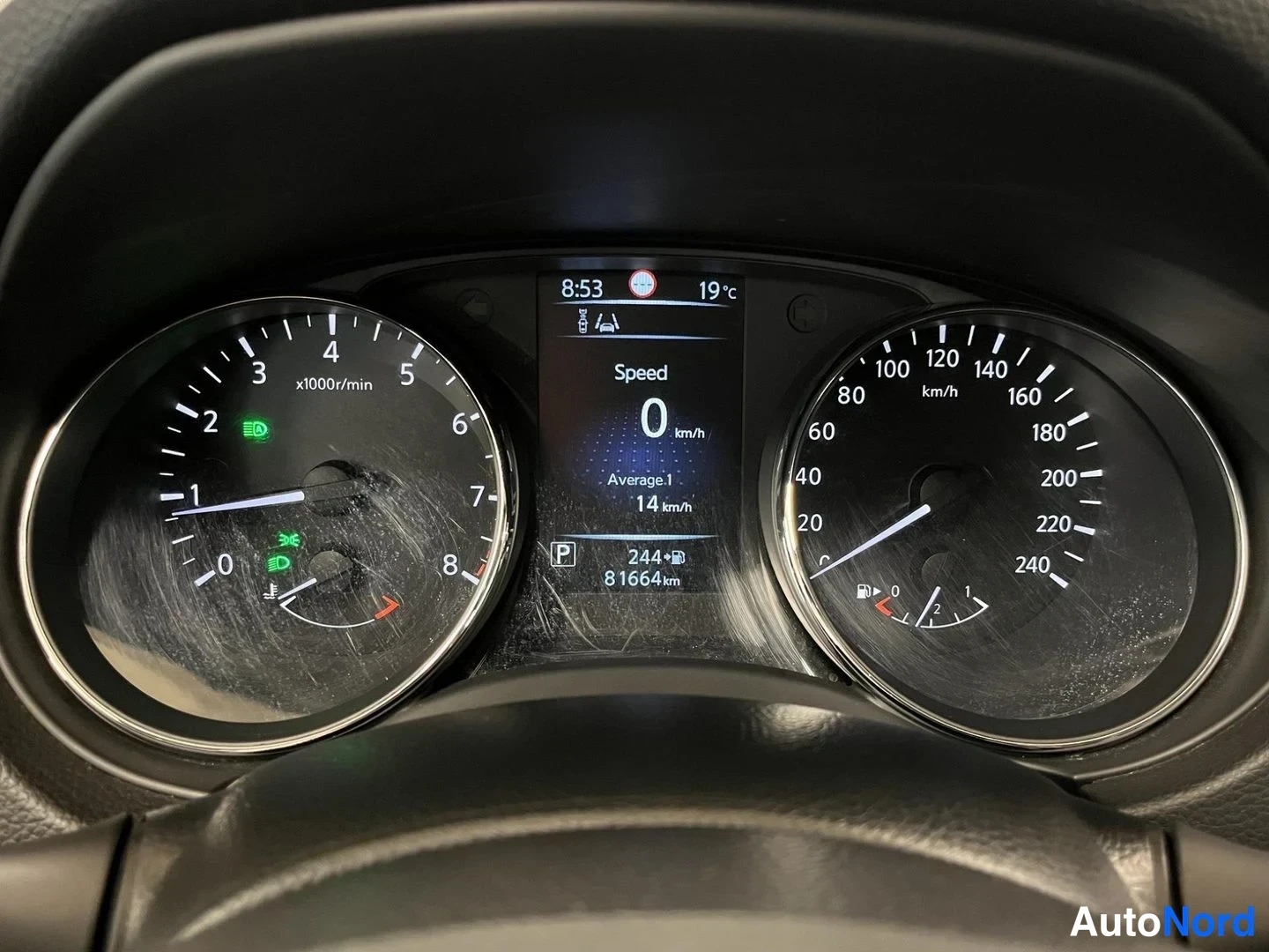 Muu: Kojelauta lähikuvassa: nopeusmittari 0 km/h, näytössä lukemat 81664 km, P-merkki ja lämpötila 19 °C; paneelissa naarmuja ja häikäisyä.
