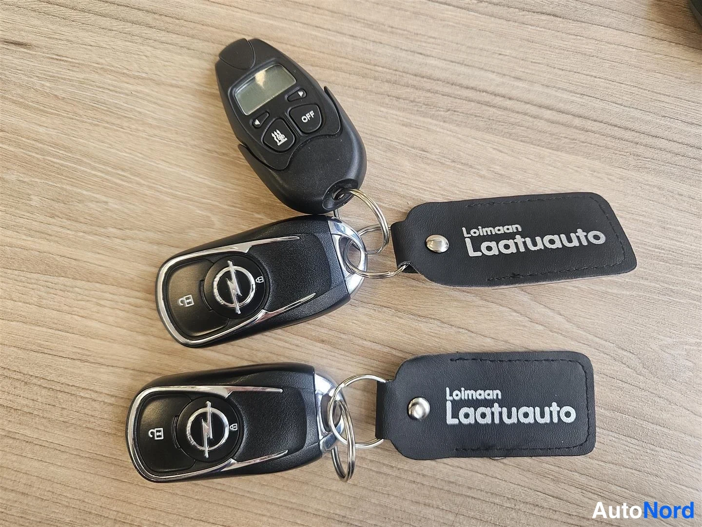 Muu: Kaksi Opel-avainnimikettä ja musta kauko-ohjain avaimenperässä, mukana kaksi 'Loimaan Laatuauto'-nimikettä.