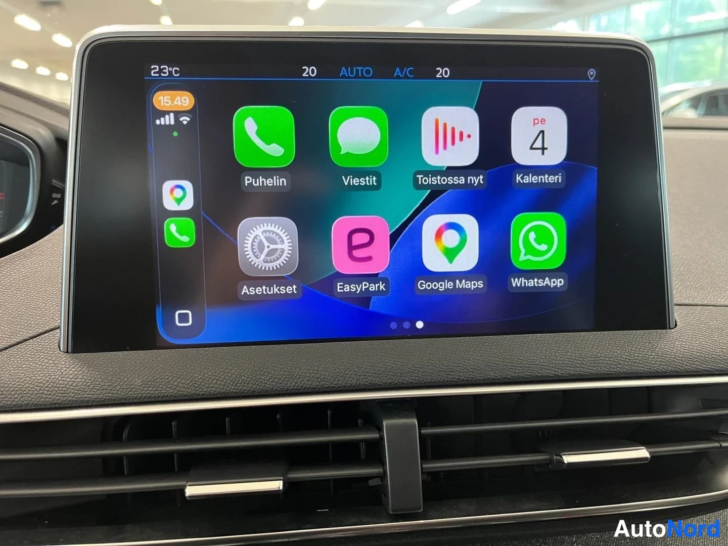 Muu: Auton kosketusnäytön CarPlay-aloitusruutu sovelluksilla Puhelin, Viestit, Toistossa nyt, Kalenteri, Asetukset, EasyPark, Google Maps ja WhatsApp.