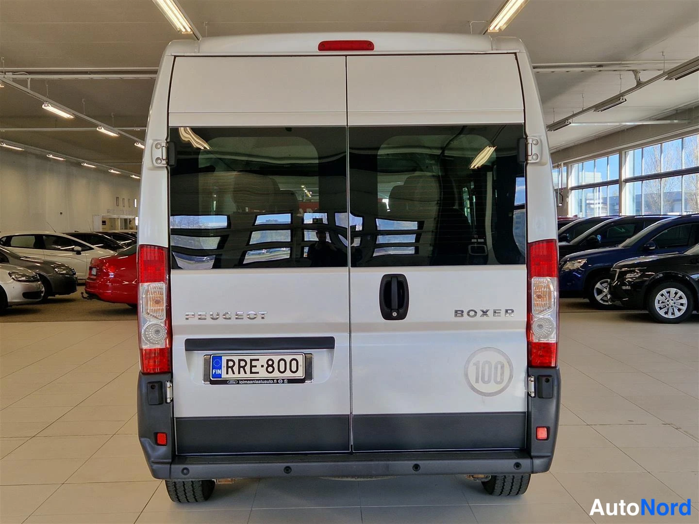 Takaa: Peugeot Boxer -pakettiauton takaosa autocarhallissa; takanupit, Peugeot- ja Boxer-merkit sekä rekisterikilpi.