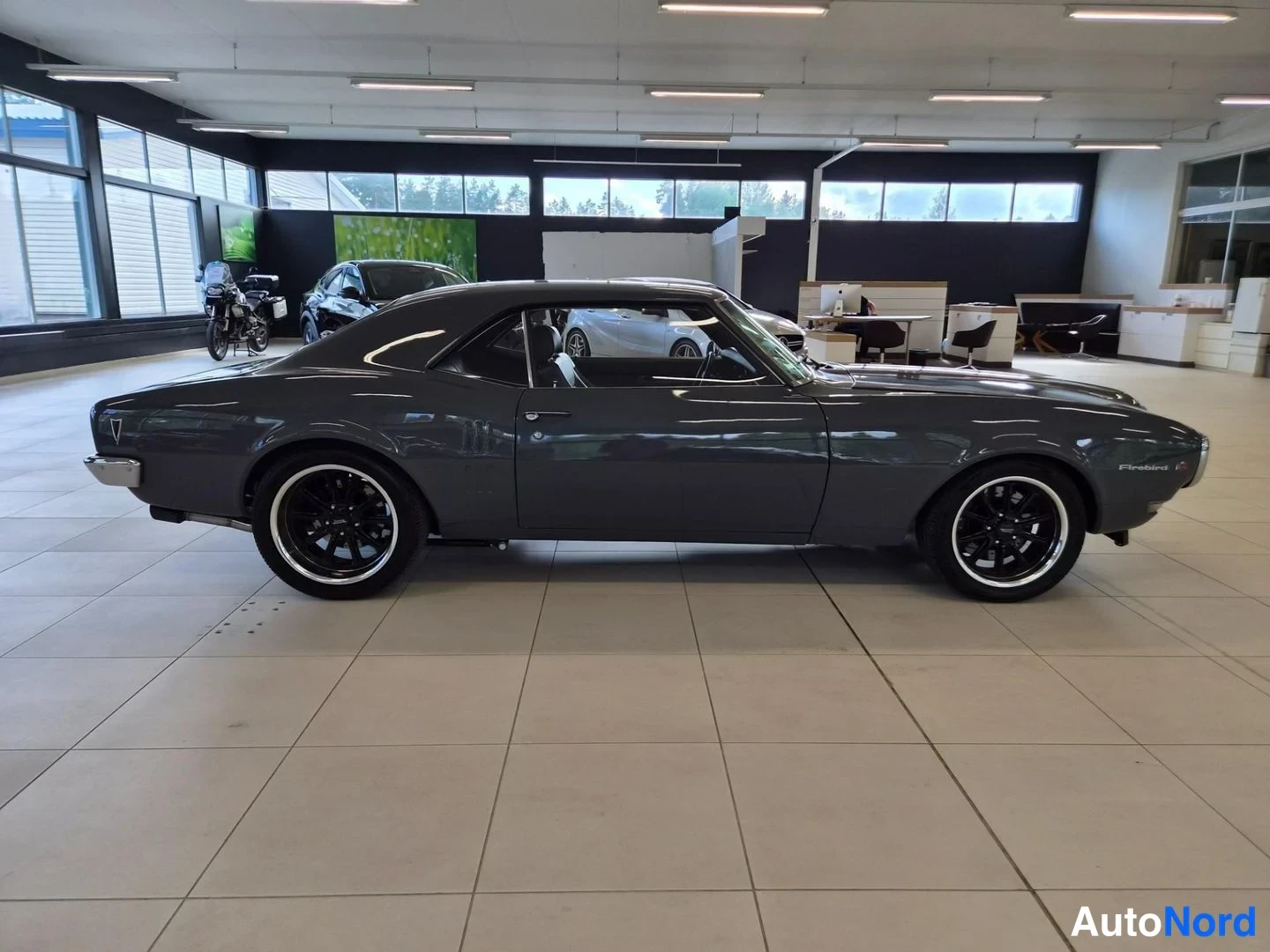 Sivulta: Firebird-coupe sivulta vasemmalta autonäyttelytilassa; mustat vanteet, kromipuskurit ja Firebird-tunnus etulokasuojassa.