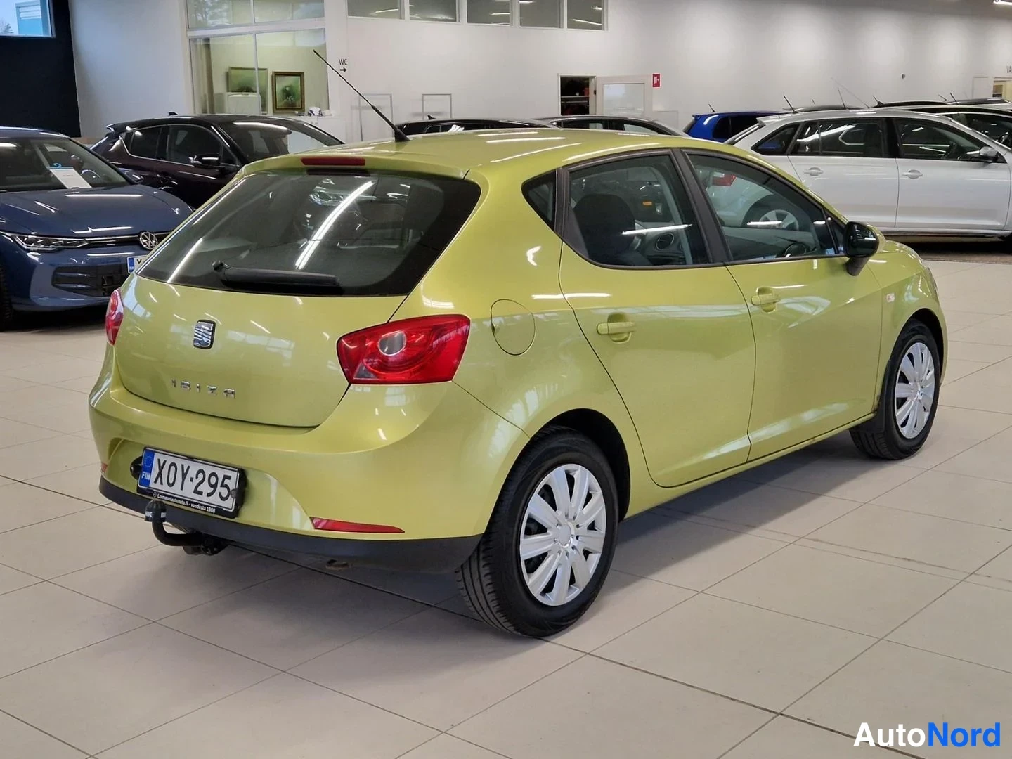 Takaviisto: Keltavihreän Seat Ibizan takakulma vasemmalta; rekisterikilpi X0Y-295, tavaratilan lukon kirainveto, vetoautokytkin.