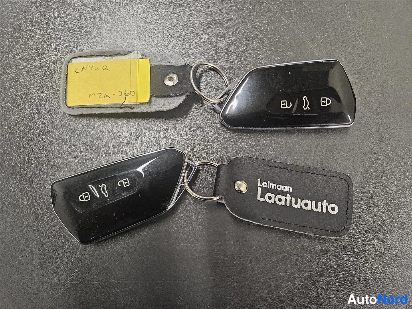 Muu: Kaksi mustaa Skoda-avainkaukana renkaassa ja nahkainen avainnippu, johon on painettu 'Loimaan Laatuauto'.