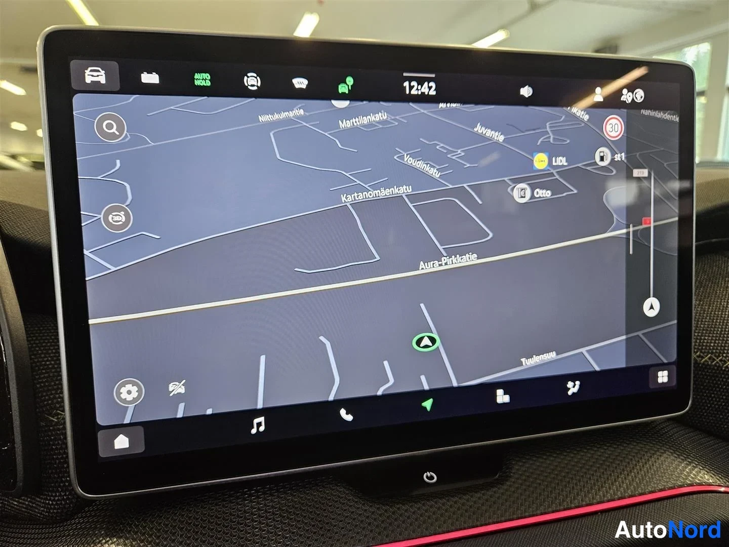 Edestä: Auton infotainment-näyttö karttanimenäkymässä Aura- Pirkatie ja lähiympäristön katuja Turussa.