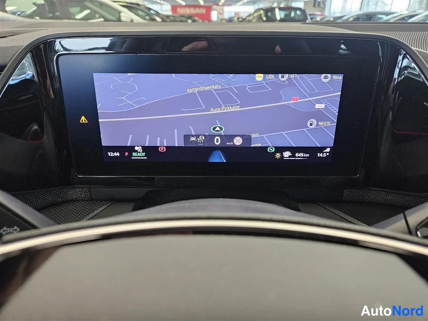 Muu: Sisäkuva: auton infotainment-näytön navigointikartta, jossa näkyvät kadut Kartanomäenkatu ja Aura-Pyrkkatie, nopeusrajoitus 30 ja rekka km 645.