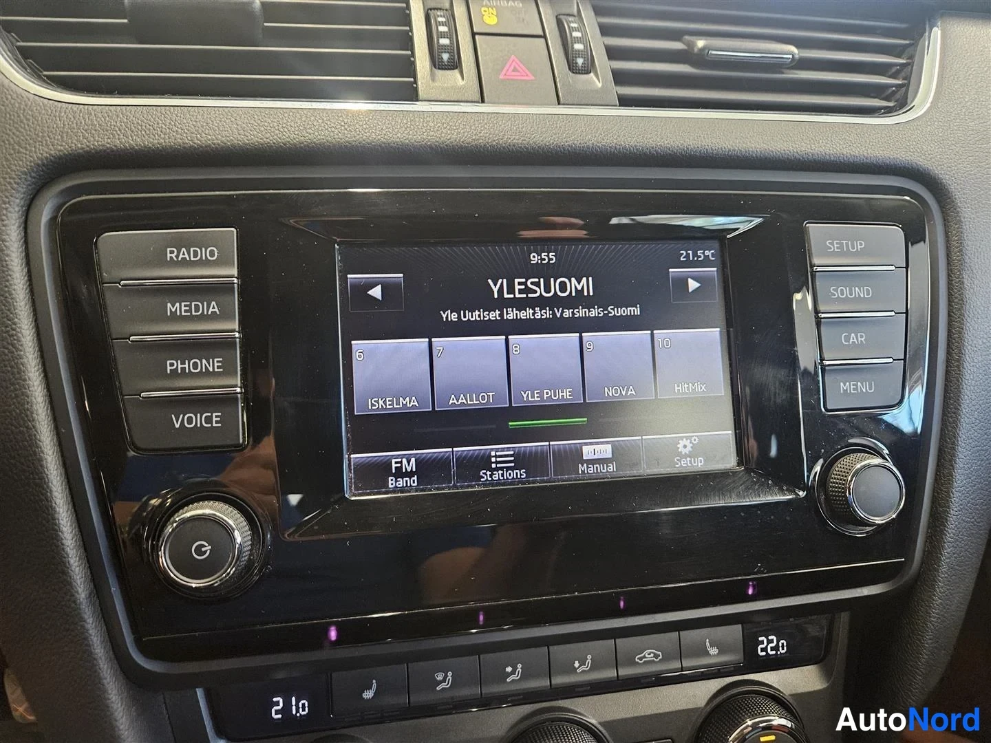 Yksityiskohta: Viihdejärjestelmän näyttö näyttää YLE Suomi -radioasemalistan; sivunapeissa RADIO, MEDIA, PHONE, VOICE, SETUP, SOUND, CAR, MENU.