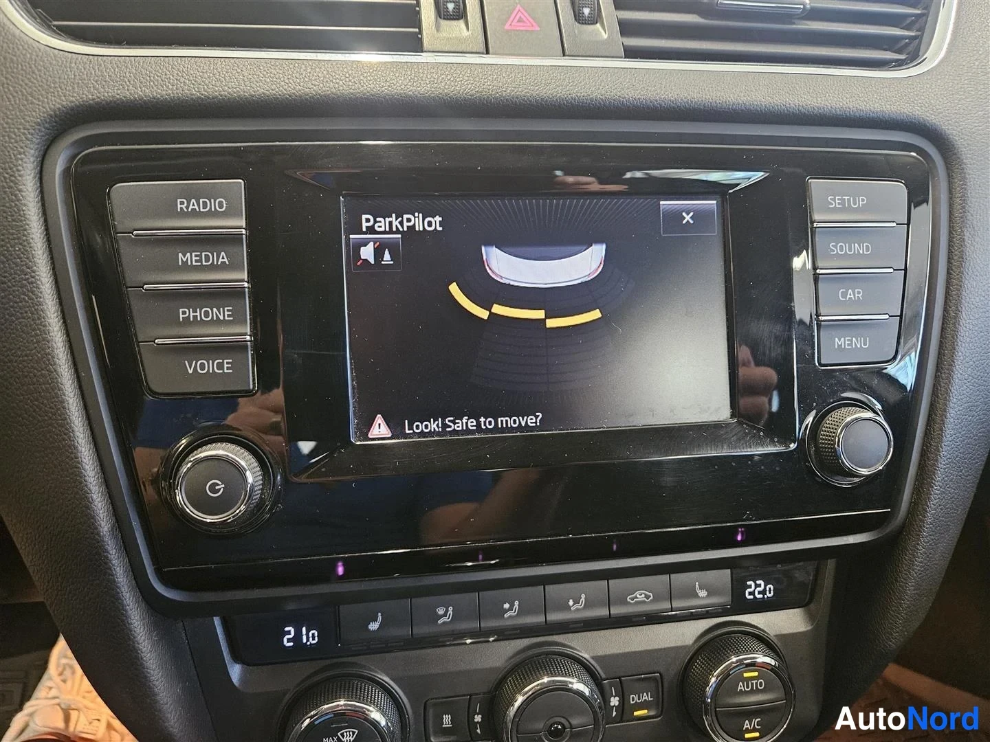 Muu: Kojelaudan infotainment-näyttö, jossa näkyy ParkPilot-törmäystunnistin ja teksti 'Look! Safe to move?', ympärillä RADIO/MEDIA/PHONE/VOICE- ja SETUP/SOUND/CAR/ME