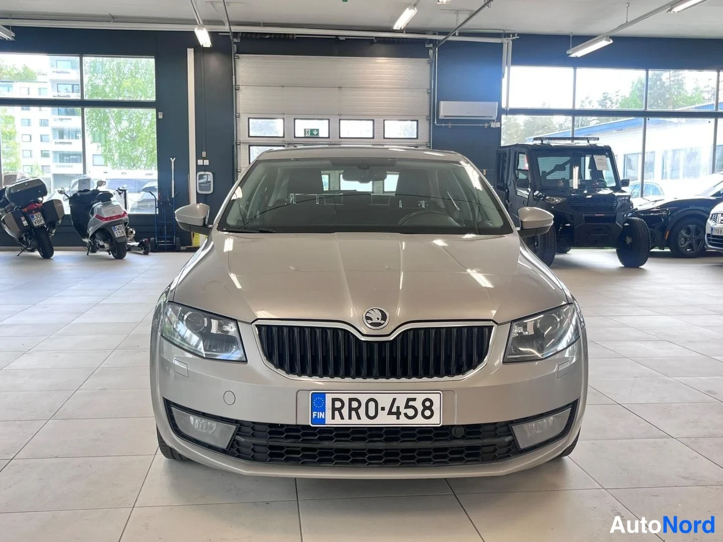Edestä: Beige Skoda Octavian etupää suoraan edestä, rekisterikilpi RR0-458 ja etusumuvalot näkyvissä.