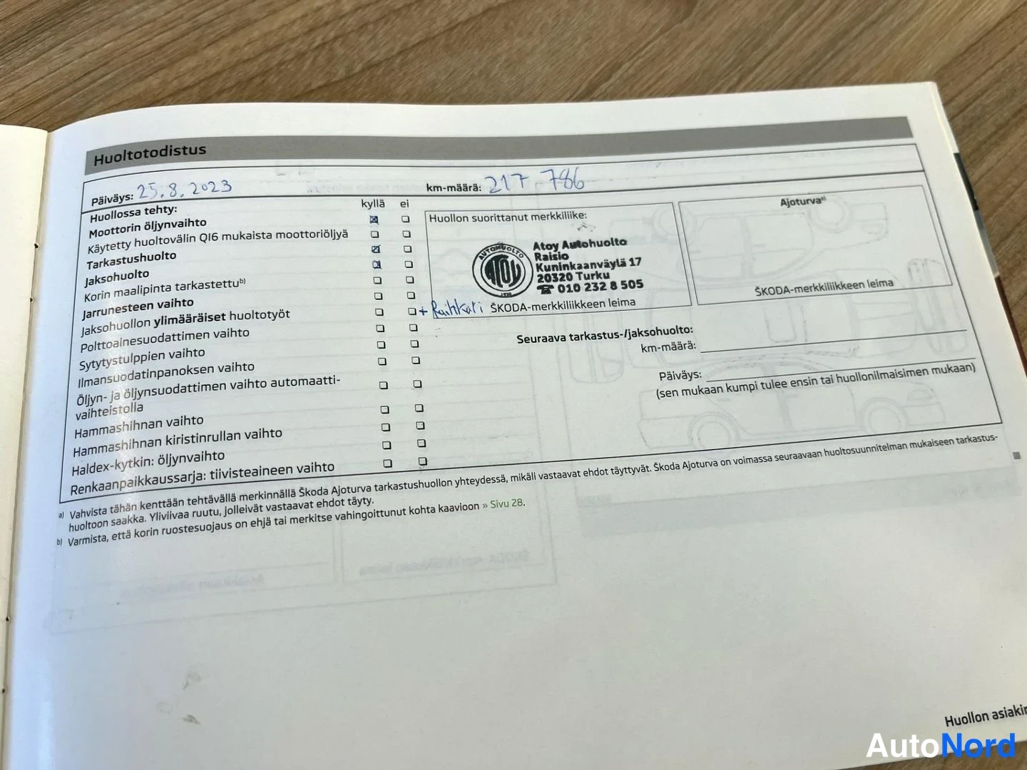 Muu: Huoltotodistuksen sivu: huolto 25.8.2023, km-määrä 217786, Atoy Autohuolto Raision leima, sekä polttoainemuodattimen vaihto merkitty.