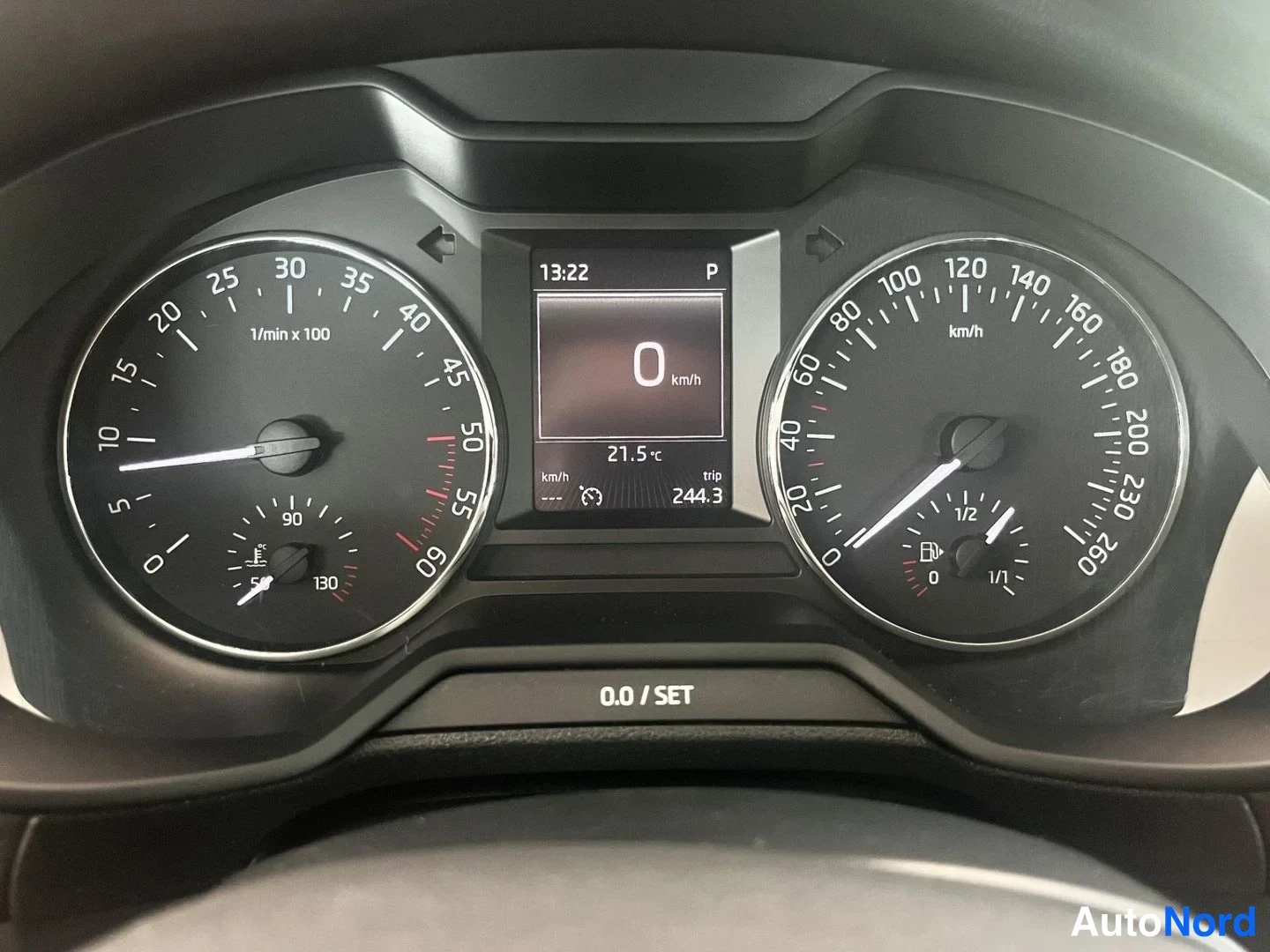 Yksityiskohta: Kojelaudan mittaristo: nopeusmittari aina 260 km/h, kierrosmittari, näytössä 0 km/h, 21,5 °C ja matka-asetus trip 244,3.