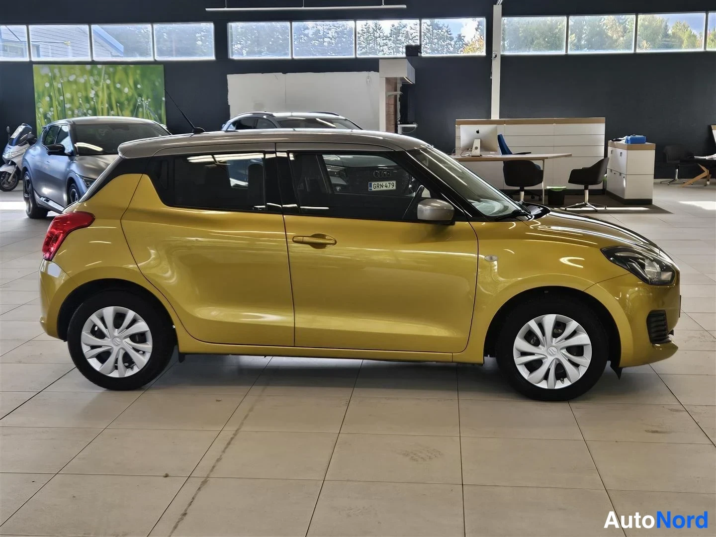 Sivulta: Keltaisen Suzuki Swiftin sivukuva oikealta puolelta; ovet, pyörät ja takavalot näkyvät sisätiloissa, rekisteritunnus 6RN-479.