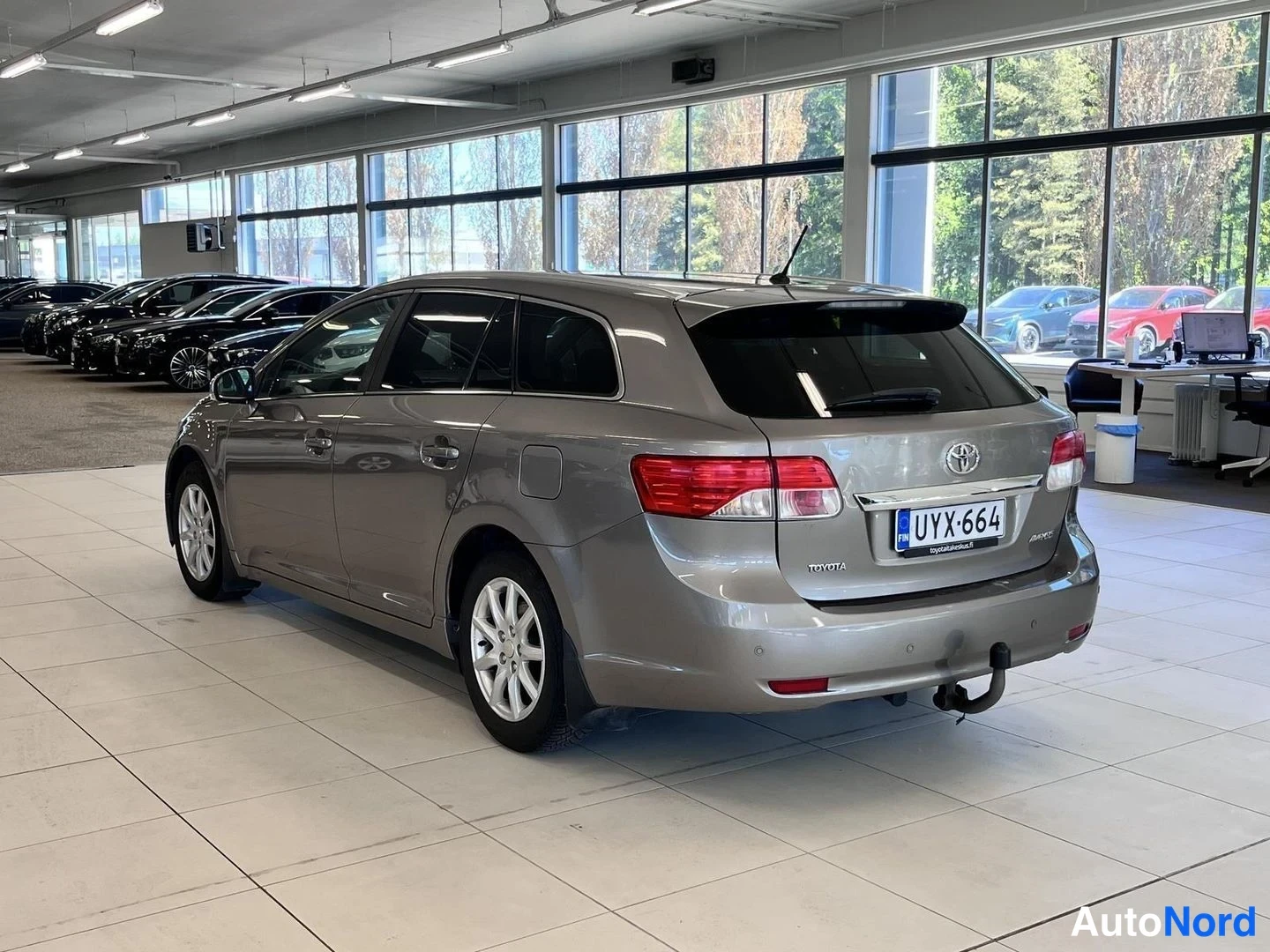 Takaviisto: Toyotan takakulmanäkymä auton vasemmalta puolelta; rekisteri ja Avensis-merkintä näkyvät.