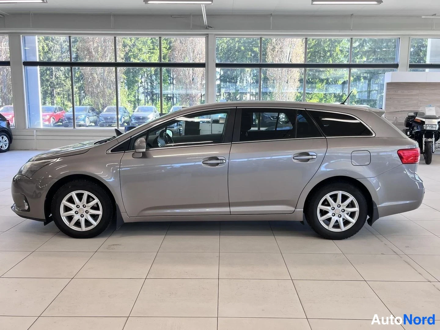 Sivulta: Toyotan sivunäkymä auton vasemmalta puolelta sisätiloissa, vihreys näkyy ikkunoista.