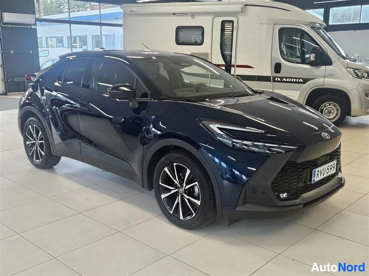 Etuviisto, nokka oikealle: Toyota C-HR etukulmasta oikealta, rekisterikilpi ja monihaarainen alumiinivanne.