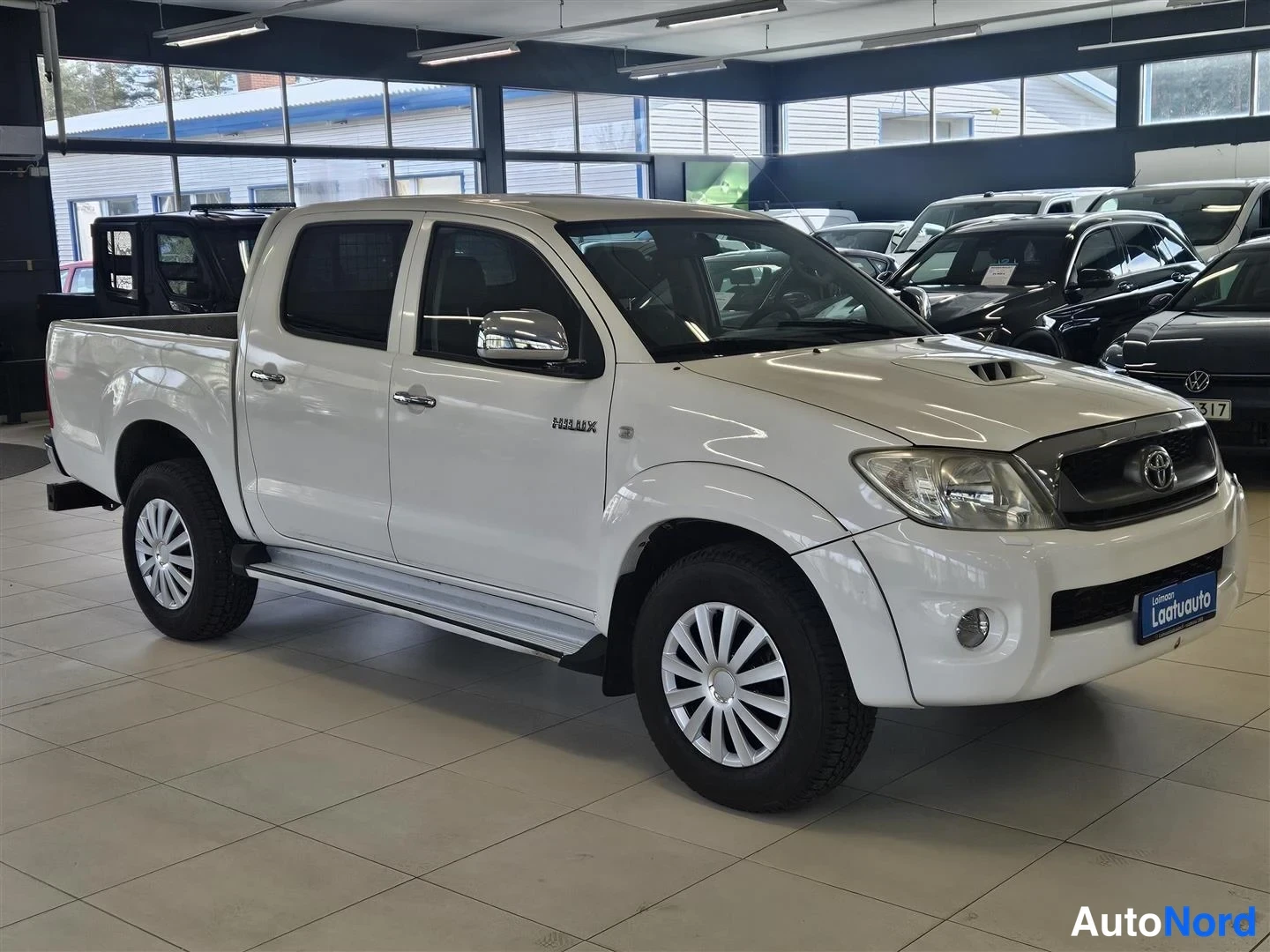 Valkoinen Toyota Hilux 2011, etuviisto, keula oikealle, kuva 2