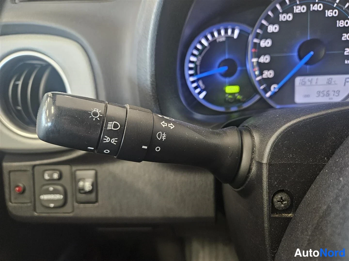 Muu: Sisätilakuva: mittaristö ja valokytkinvipu, odometeri näyttää 99579 km.