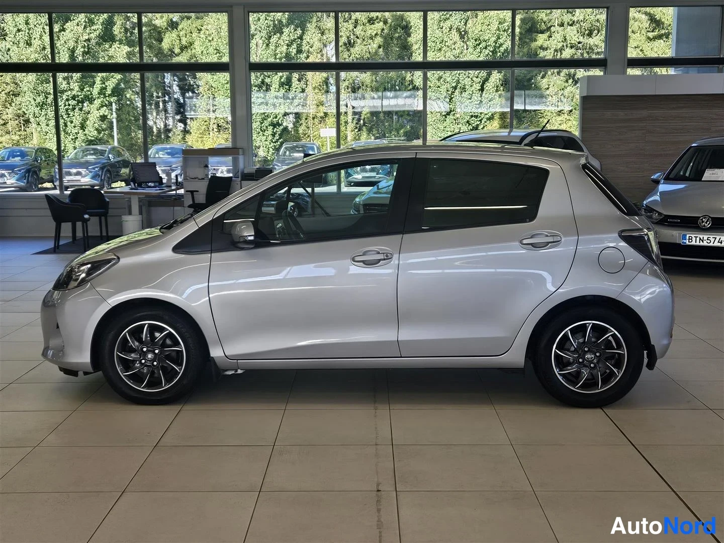 Sivulta: Hopeanvärinen Toyota Yaris sivulta vasemmalta, viisiovinen viistoperä.