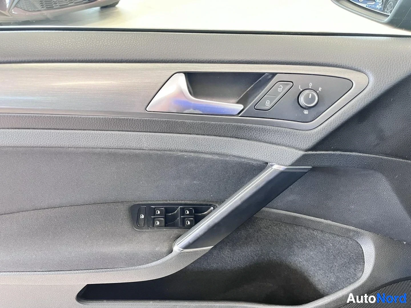 Muu: Auto-oven sisäpaneeli: ovikahva, peilinsäätökiekko (L, 0, R), lukituspainikkeet ja ikkunankytkimet.