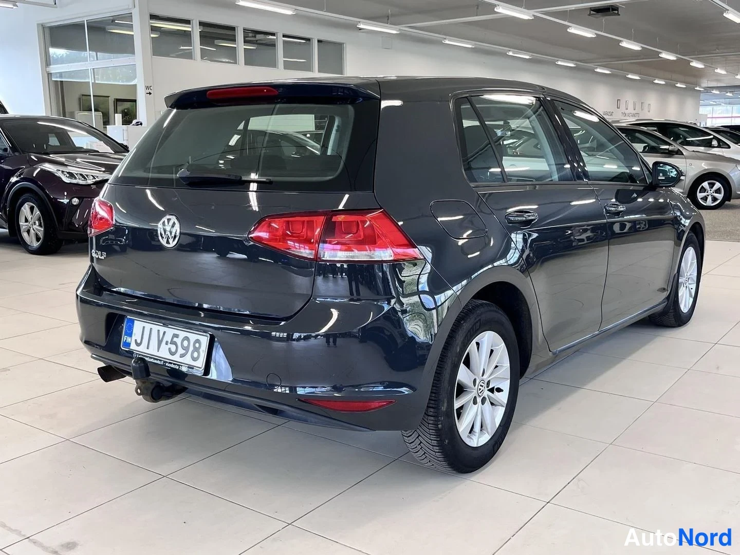 Takaviisto: Tummanharmaan Volkswagen Golfin takaosa ja oikea kylki näkyvät vinosti autonkulma­kuvassa; rekisteri ja vetokoukku näkyvät.