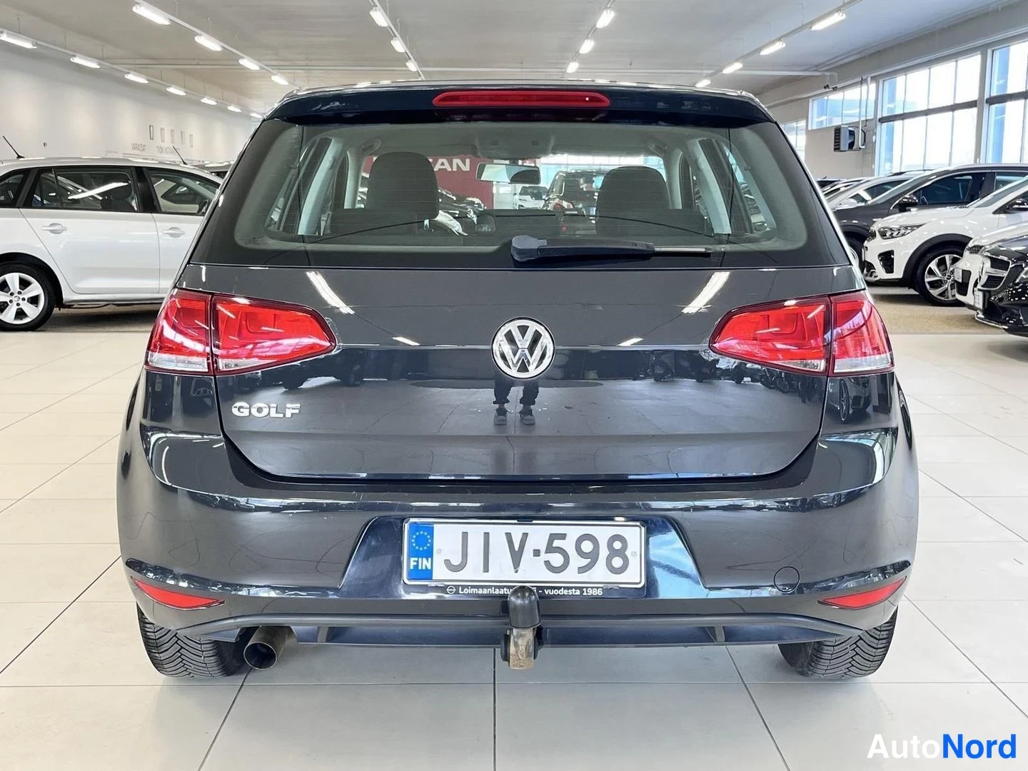 Takaa: Volkswagen Golfin takaosa suoraan takaa: GOLF-teksti, avattava takalasi, rekisteri ja takapuskurin vetokoukku.
