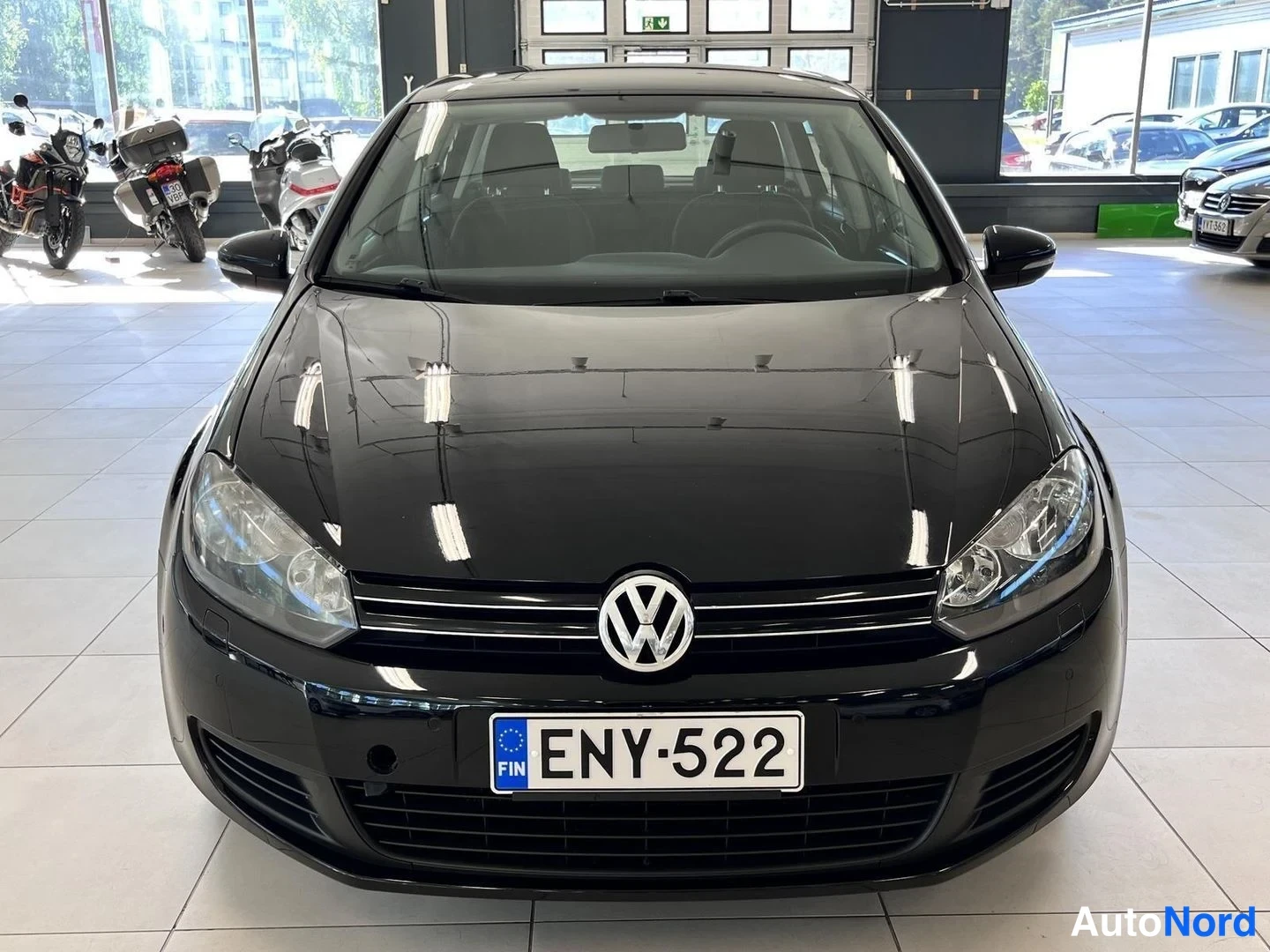 Edestä: Volkswagen Golfin etunäkymä showroomissa, kyltti.