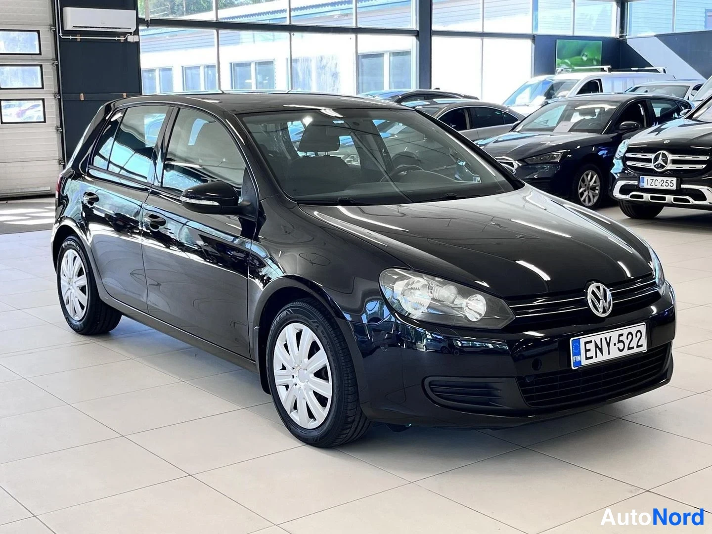 Takaviisto: Mustan Volkswagen Golfin takakulma showroomissa, rekisterikilpi.