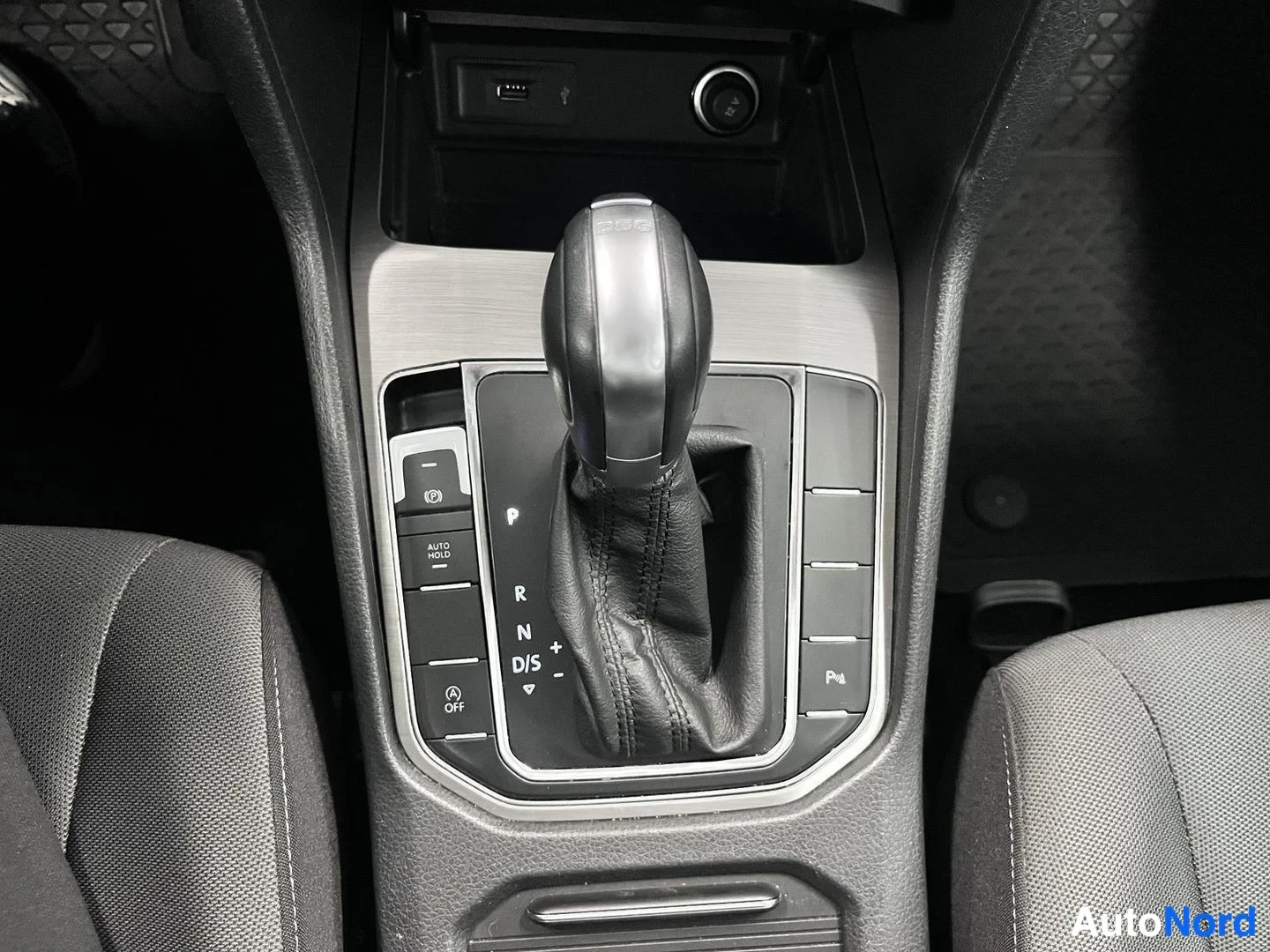 Muu: Lähikuva automaattivaihteen valitsimesta: vaihteet P, R, N, D/S, AUTO HOLD - ja sähkömekaanisen parkkijarrun painikkeet sekä USB-portti ja 12 V pistorasia edess