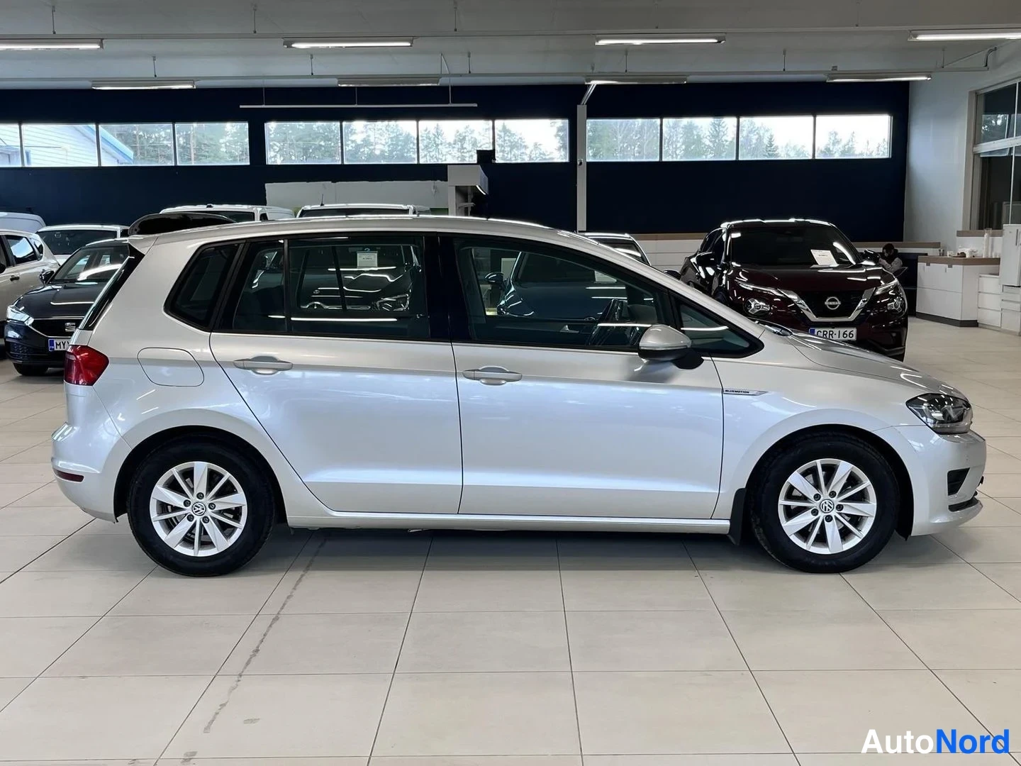 Sivulta: Volkswagen Golf Sportsvanin sivunäkymä autonäyttelytilassa.