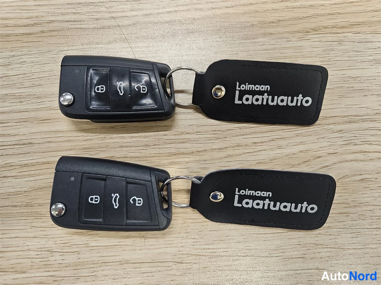 Yksityiskohta: Kaksi mustaa mallia avaimenperällä Loimaan Laatuauto-tekstillä.