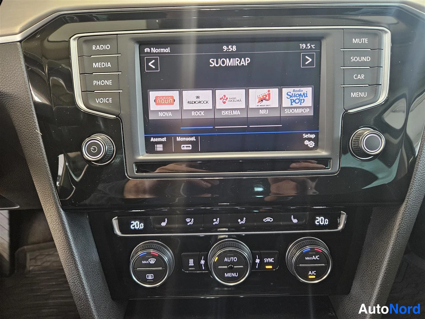 Muu: Volkswagenin radiojärjestelmän näyttö ja cliima-paneeli: suomalaisten radiokanavien tilitysnäkymä, lämpötila 20 astetta, AUTO-, SYNC- ja A/C-napit.