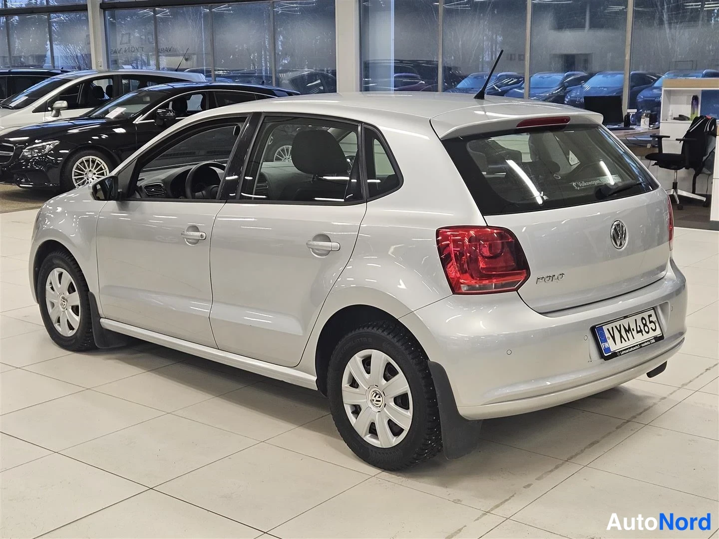 Takaviisto: Hopeanvärinen Volkswagen Polo -viistoperä autosta takaa ja vasemmalta sivulta kuvattuna autonäyttelyssä.