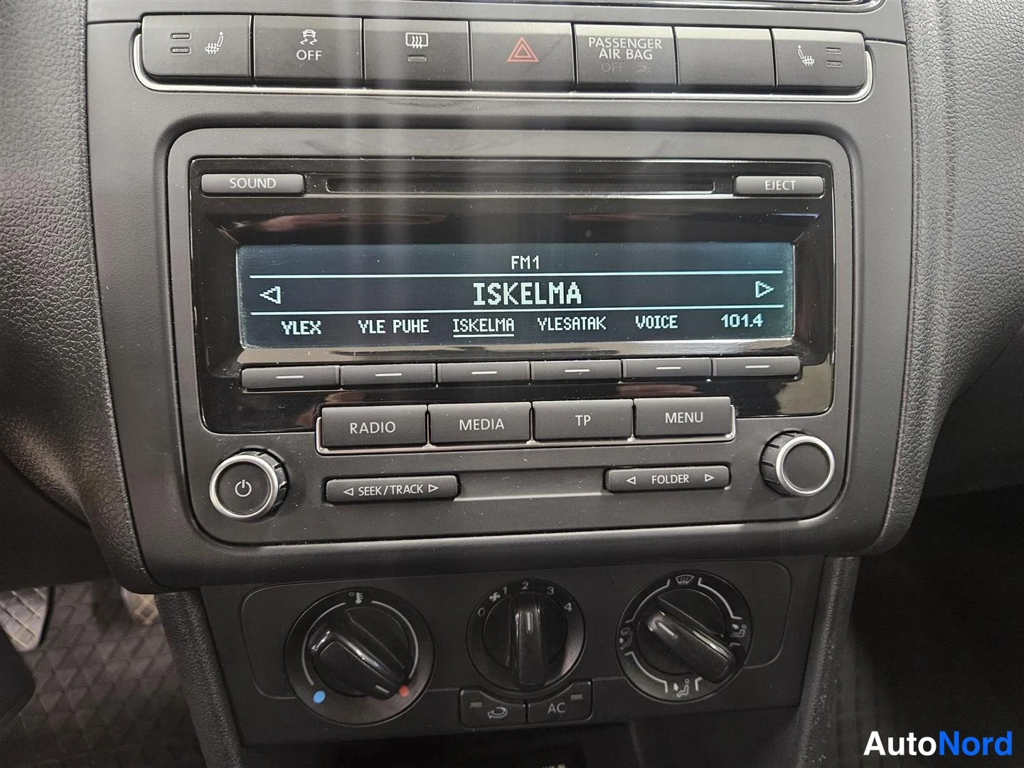 Muu: Radiopaneelin lähikuva: näytöllä FM1 ja 'ISKELMA', napit SOUND, EJECT, RADIO, MEDIA, TP, MENU sekä alle ilmastoinnin säädöt.