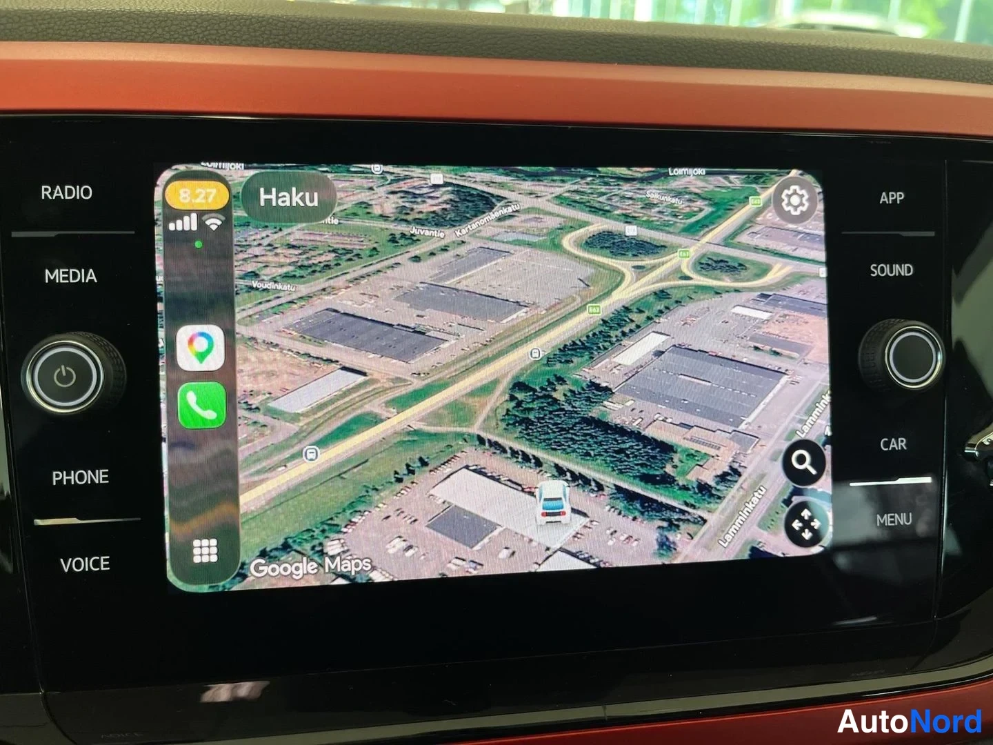 Yksityiskohta: Infotainment-näyttö, jolla näkyy Google Maps satelliittinäkymä Haku-toiminnolla ja auton sijaintimerkki parkkipaikalla.