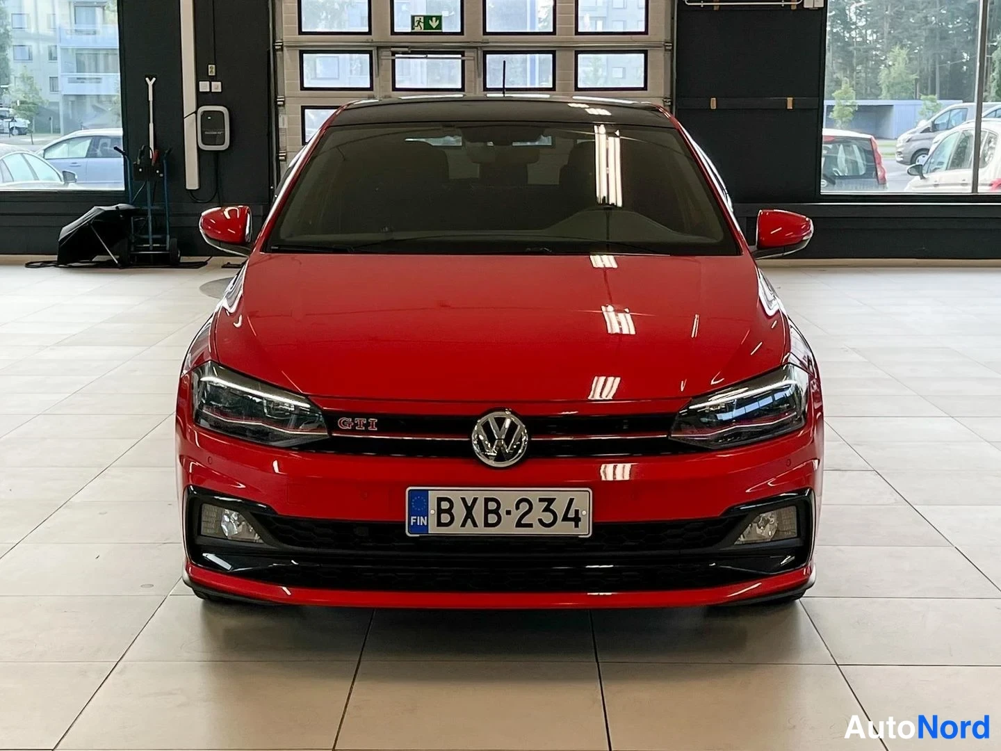 Edestä: Punainen Volkswagen Polo GTI edestäpäin, rekisteritunnus, GTI-merkintä etusäleikössä.