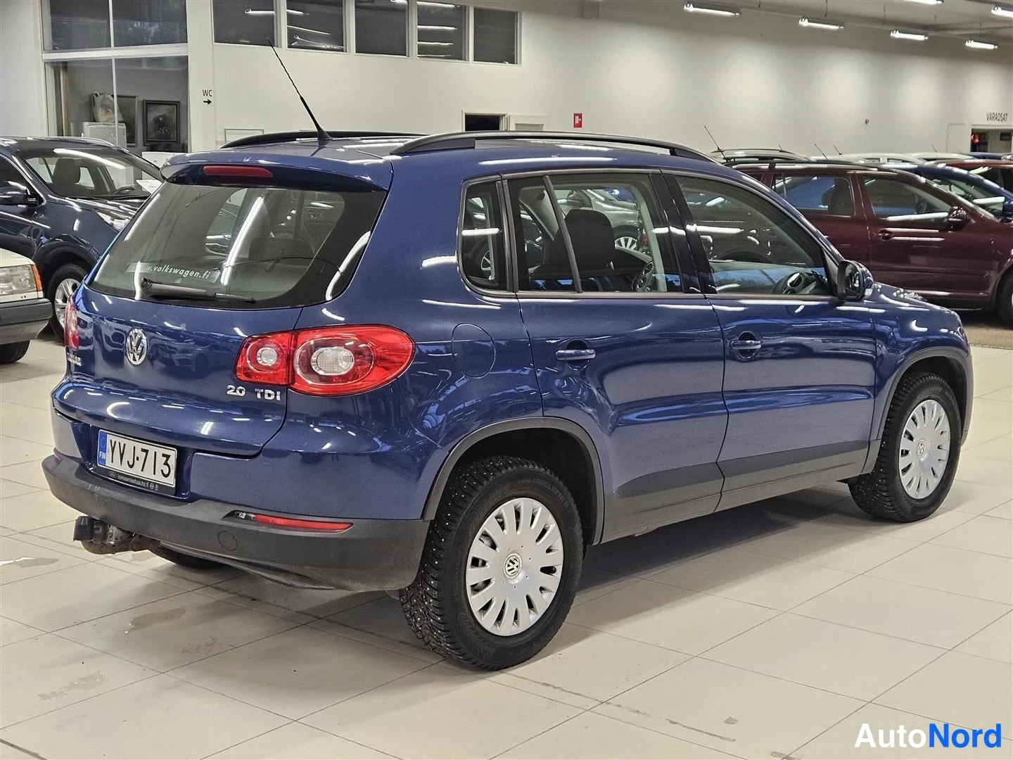 Takaviisto: Sininen Volkswagen Tiguan kulmaesitys takaa oikealta, perällä 2.0 TDI -teksti ja rekisterikilpi.