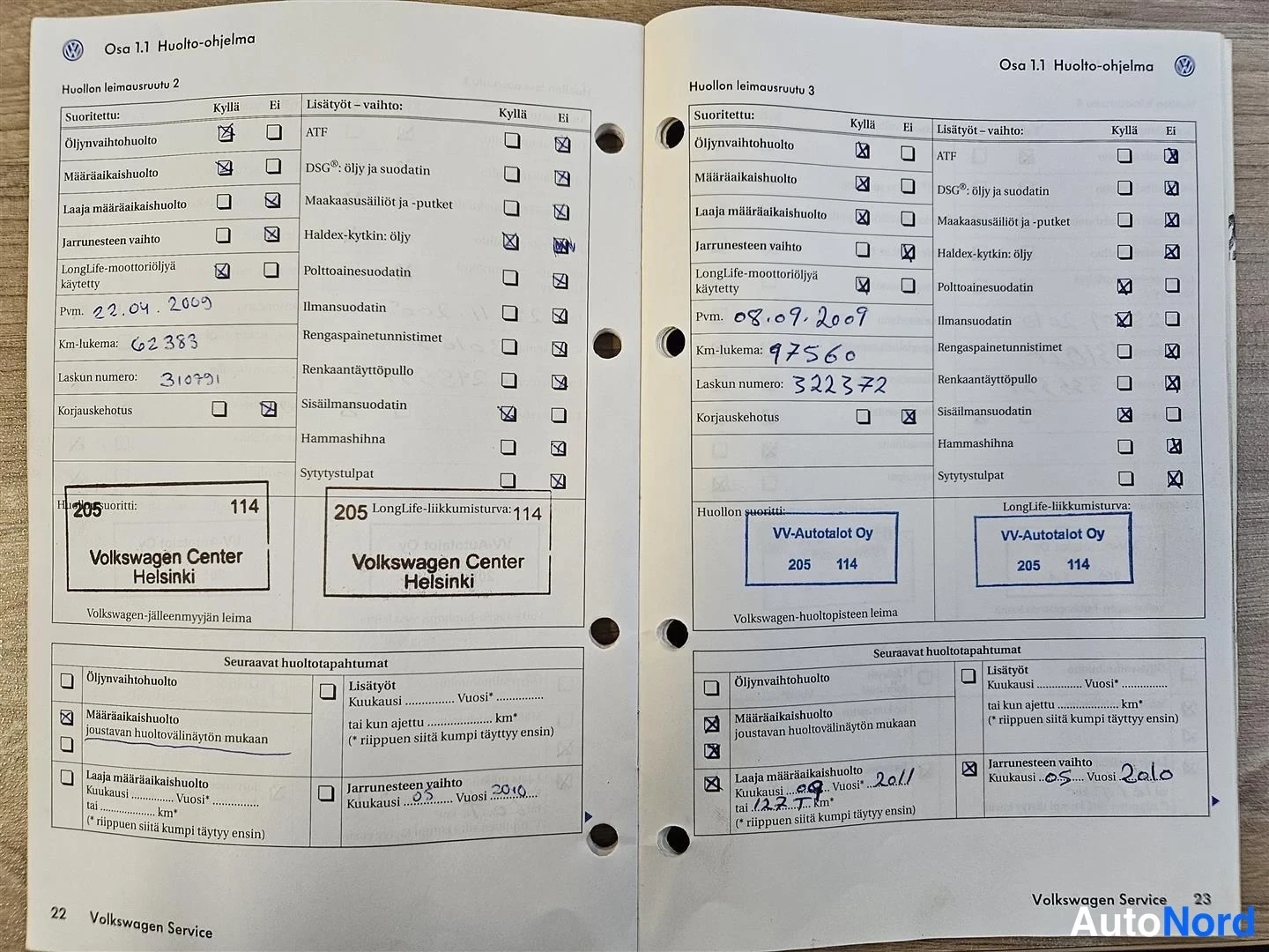 Yksityiskohta: Auki levitetty Volkswagenin huoltokirja, jossa täytetyt huoltoleimausruudut 2 ja 3 päivämäärineen ja kilometrilukemineen.