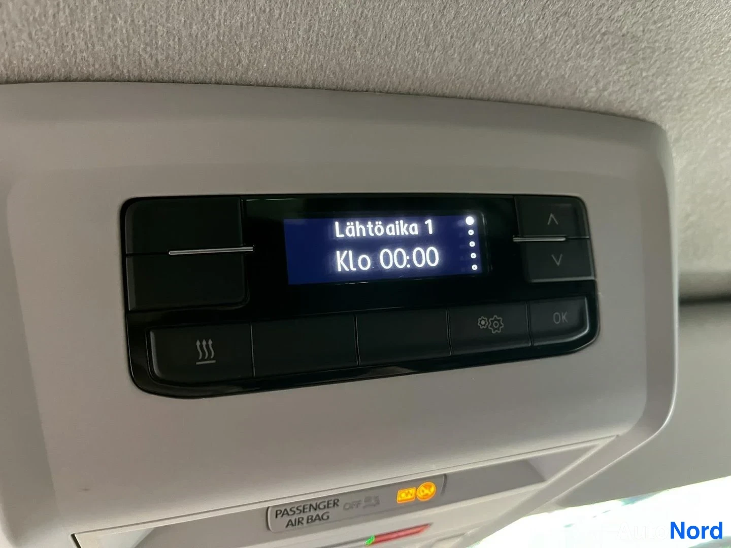 Muu: Täysi otokuva: katto paneelin näyttö, jossa teksti 'Lähtöaika 1' ja 'Klo 00:00'; alapuolella kyltti 'PASSENGER AIR BAG'.