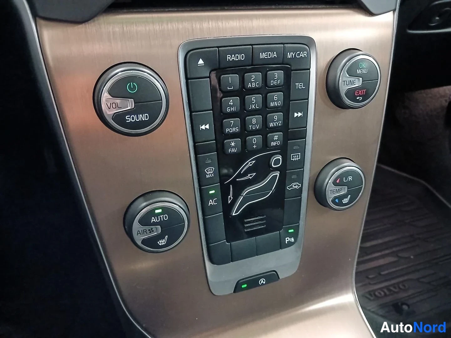 Yksityiskohta: Keskikonsolin pitkä näppäimistö ja säätimet: VOL/SOUND, RADIO, MEDIA, MY CAR, TEL, AUTO-ilmastointi ja L/R TEMP -sarvi.