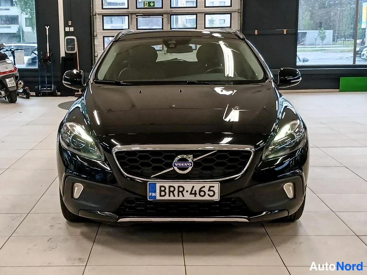Edestä: Etukuvamustasta Volvo-henkilöautosta, Volvo-merkki jäähdyttimen suojassa, rekisterikilpi