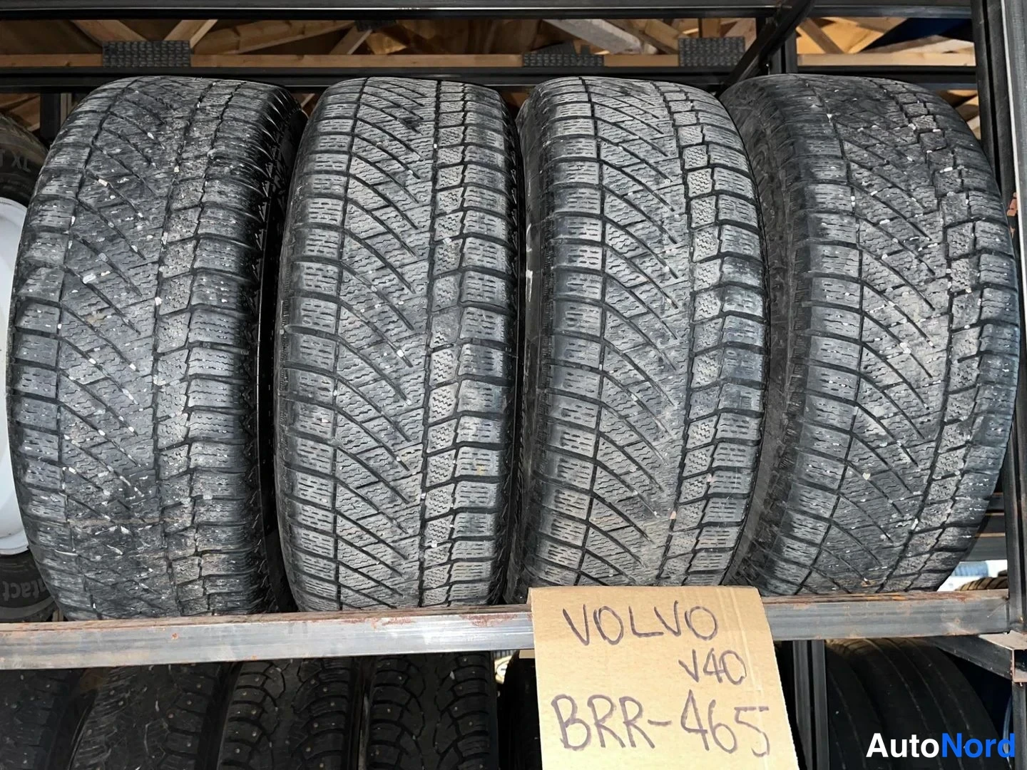 Yksityiskohta: Hyllyssä neljä talvirengastta ja karttoruupe: VOLVO V40.