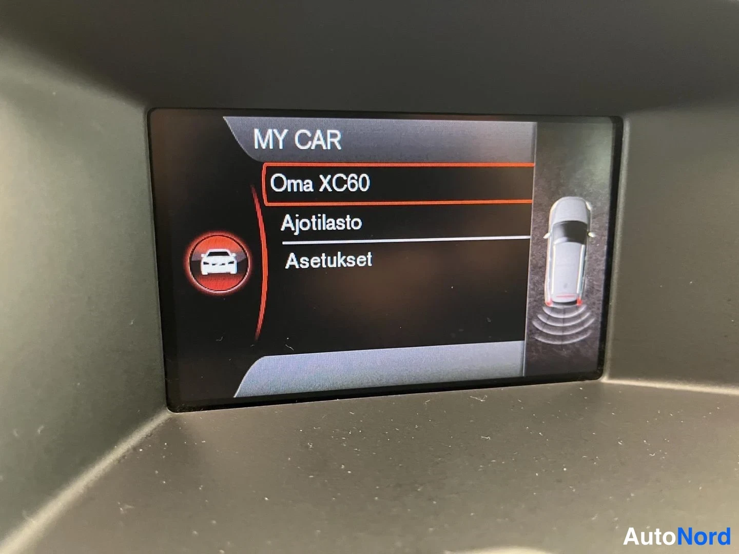 Yksityiskohta: Kojenäytössä MY CAR -valikko, jossa vaihtoehdot Oma XC60, Ajotilasto ja Asetukset, oikealla takaframigrafia.