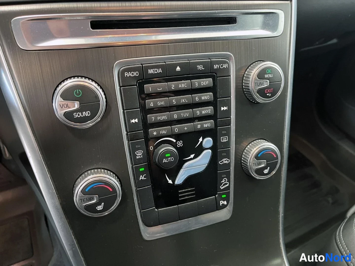 Yksityiskohta: Keskiö konsolinäppäimistö: RADIO, MEDIA, TEL, MY CAR, numeronäppäimet, VOLUME/SOUND- ja TEMP-säätimet sekä AUTO ja AC-painikkeet.