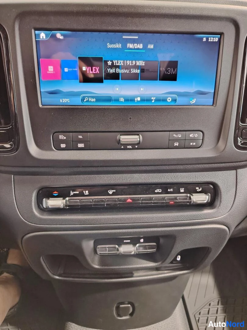 Muu: Lähikuva Mercedes-Benz Vito -auton kojelaudan kosketusnäytöstä, jossa näkyy radiovalikko Suosikit FM/DAB AM ja YLE-kanavat.