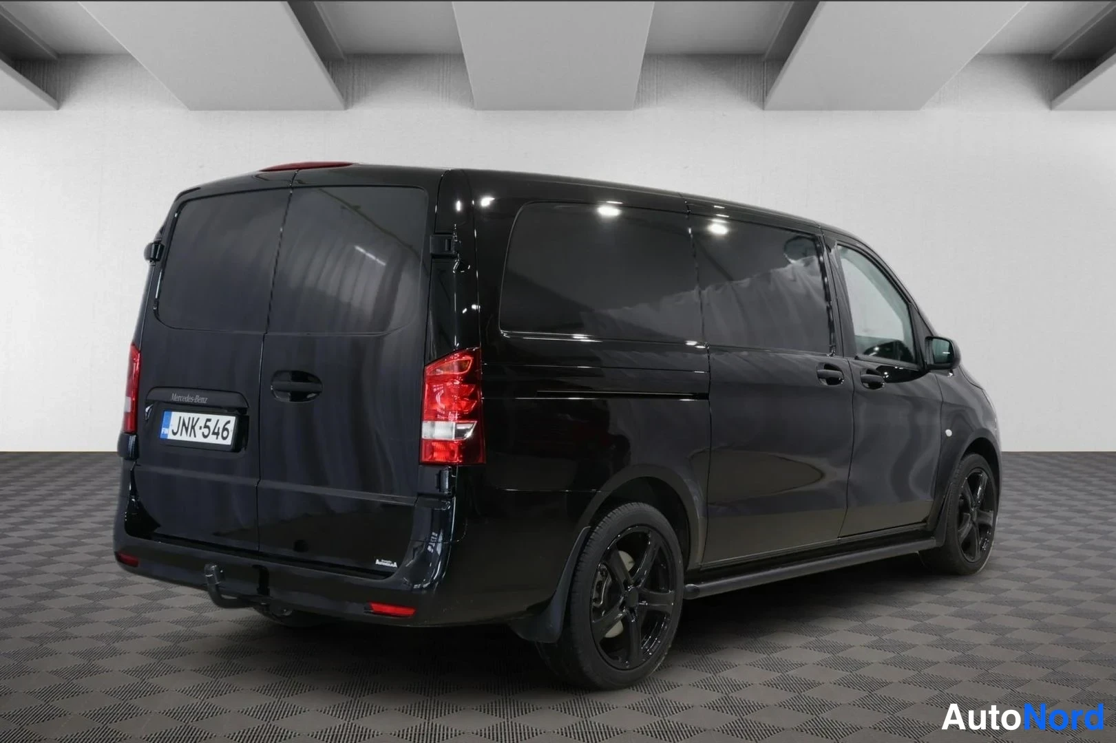 Takaviisto: Mustan Mercedes-Benz Vito -pakettiauton takaosa ja sivuprofiili kulmasta kuvattuna, rekisteritunnus.