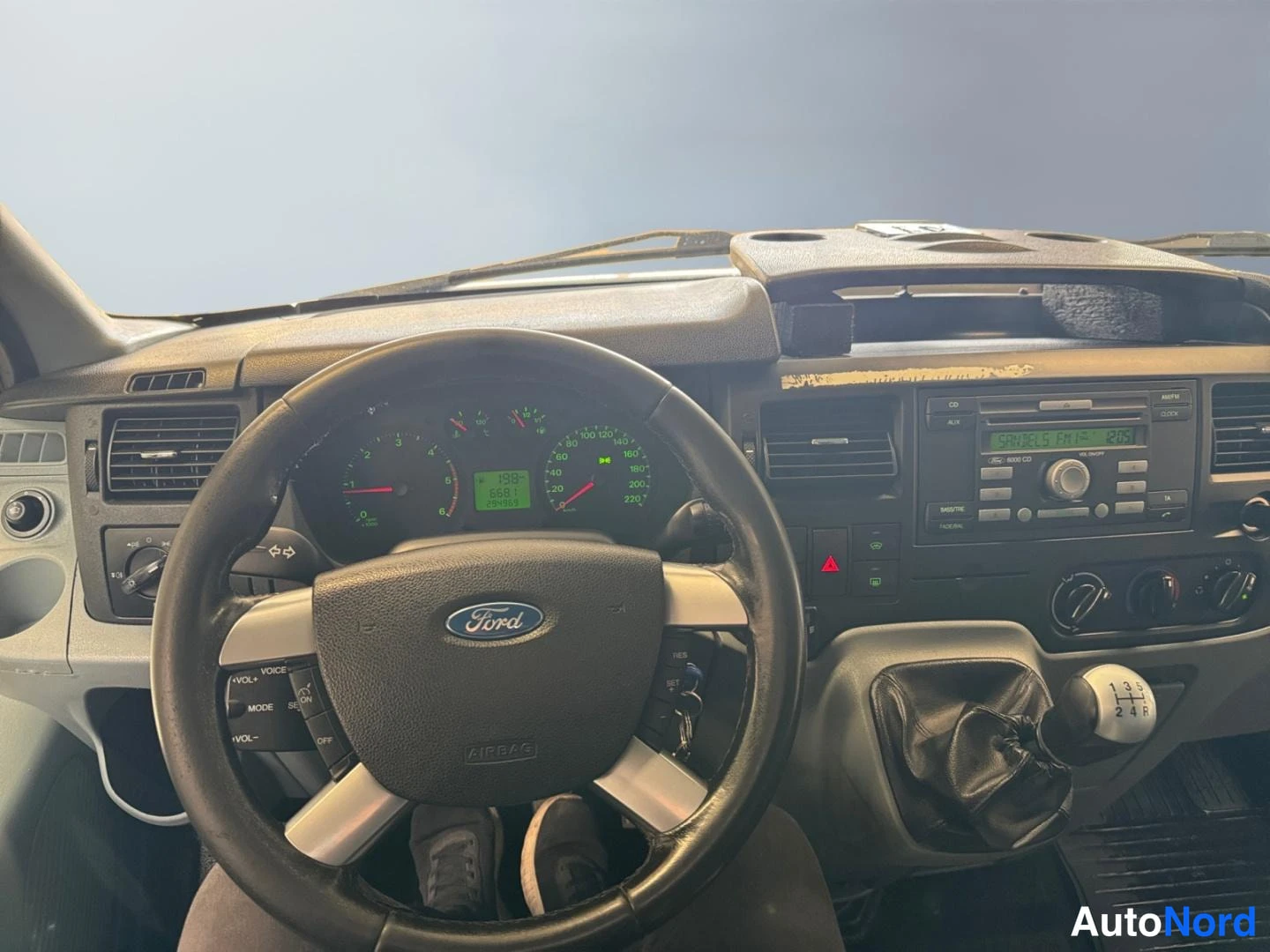 Edestä: Ford-merkkinen ohjauspyörä, mittaristo ja vaihtotanko.