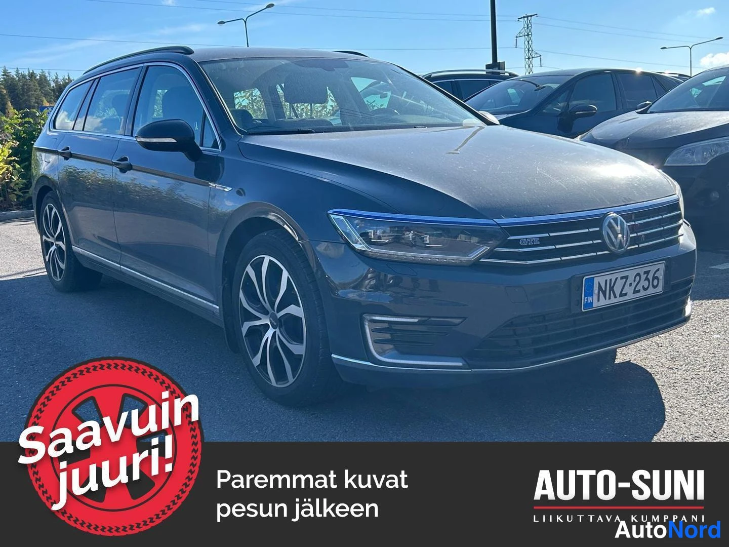 Etuviisto, nokka oikealle: Tummanharmaa farmariauto kolmesta neljännestä etuviistosta, etupuskuri ja rekisterikilpi näkyvissä.