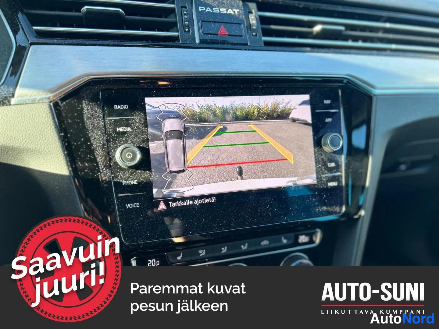 Muu: Kojelautanäyttö näyttää peruutuskameran kuvan parking-viivoineen ja auton kuvakkeineen; ilmastointi 20,0 °C ja radio-/media-/puhelin-valikot näkyvissä. Kojelaut
