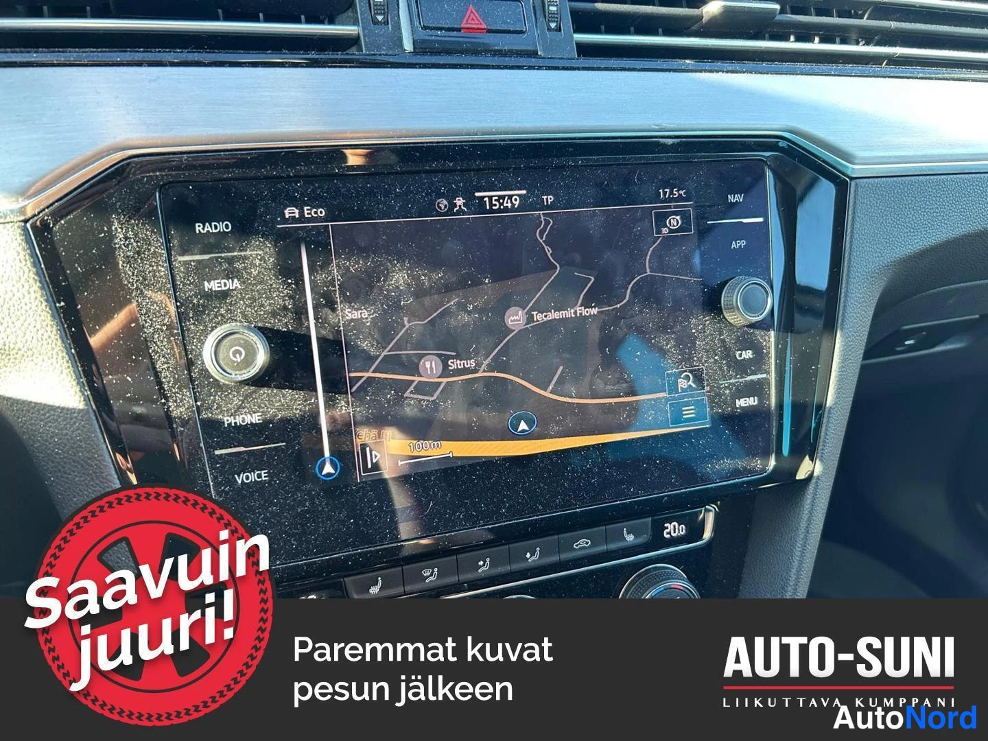 Muu: Auton kojelaudan infotainment-näyttö, jossa on navigointikartta ja radio-/mediavalikot.