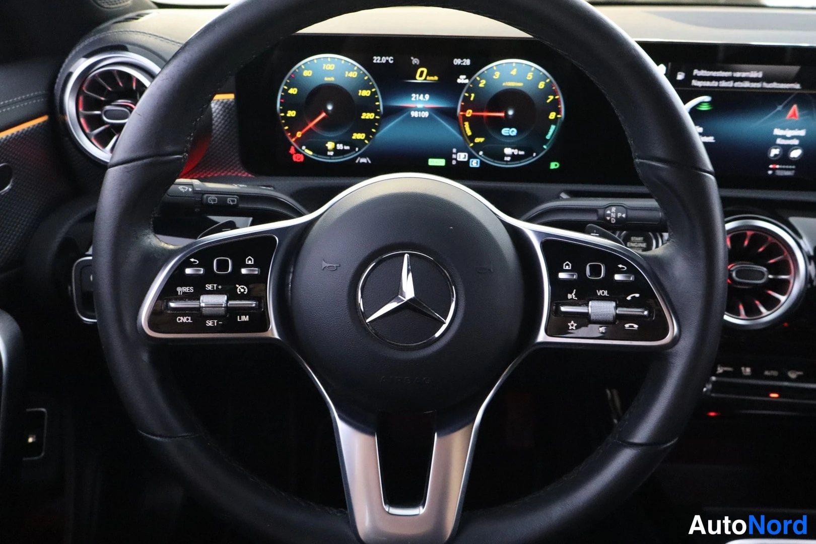 Muu: Mercedes-Benzin ohjauspyörä ja digitaalinen mittaristo sekä ilmastointilaitteet kuvattuna sisältä.