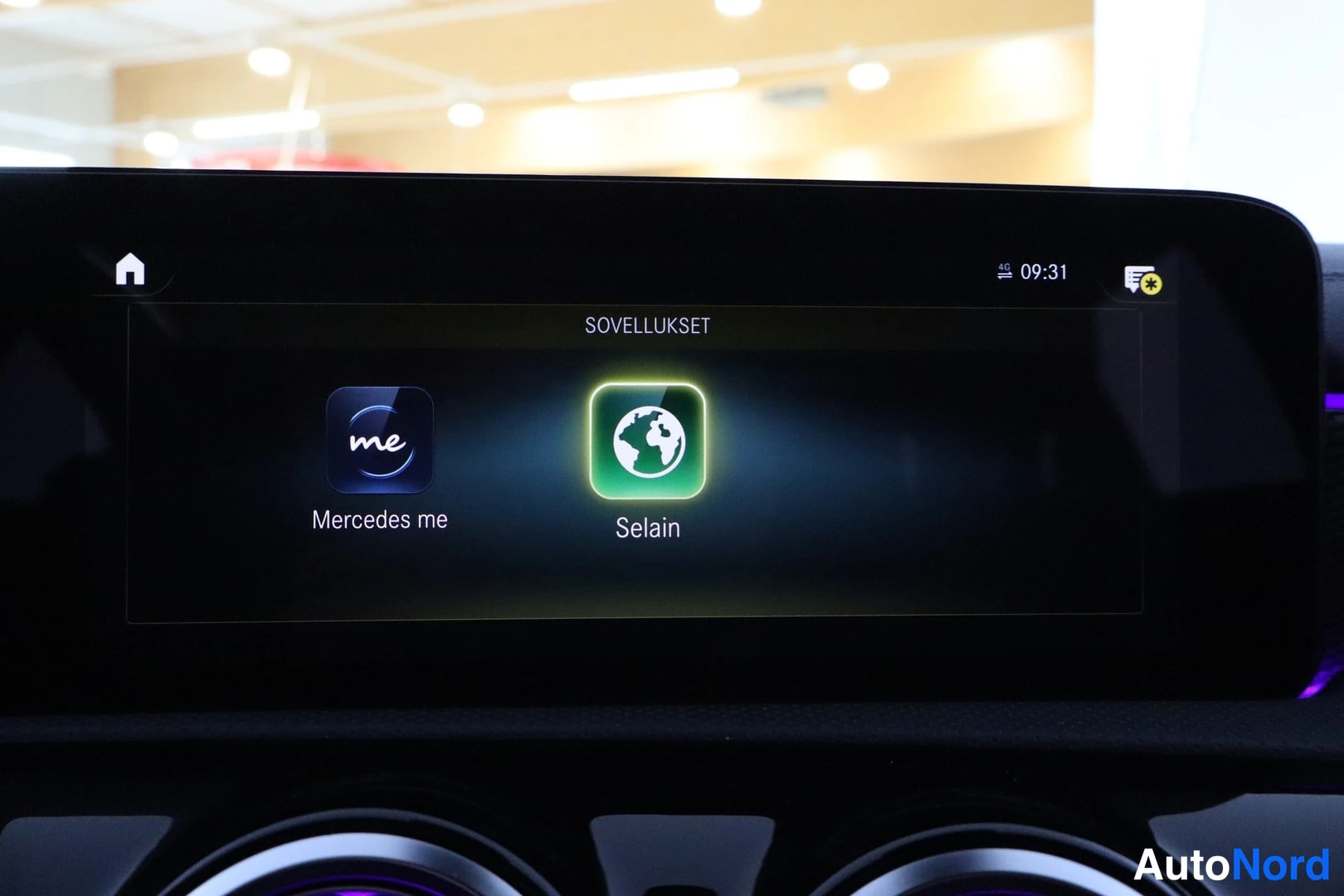 Yksityiskohta: Keskuskonsolan infotainment-näyttö näyttää Sovellukset-valikon kuvakkeineen: Mercedes me ja Selain; lisäksi koti-painike, kellonaika 09:31 ja ilmoituskuvake.